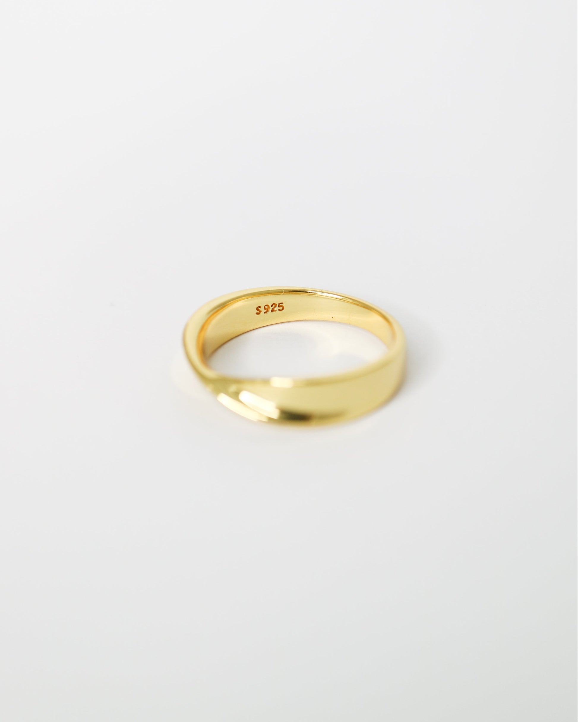 Gold ring on a light gray background