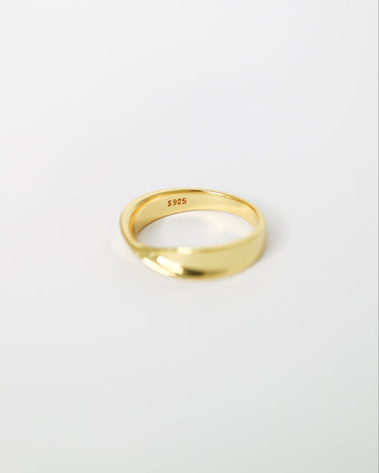 Gold ring on a light gray background