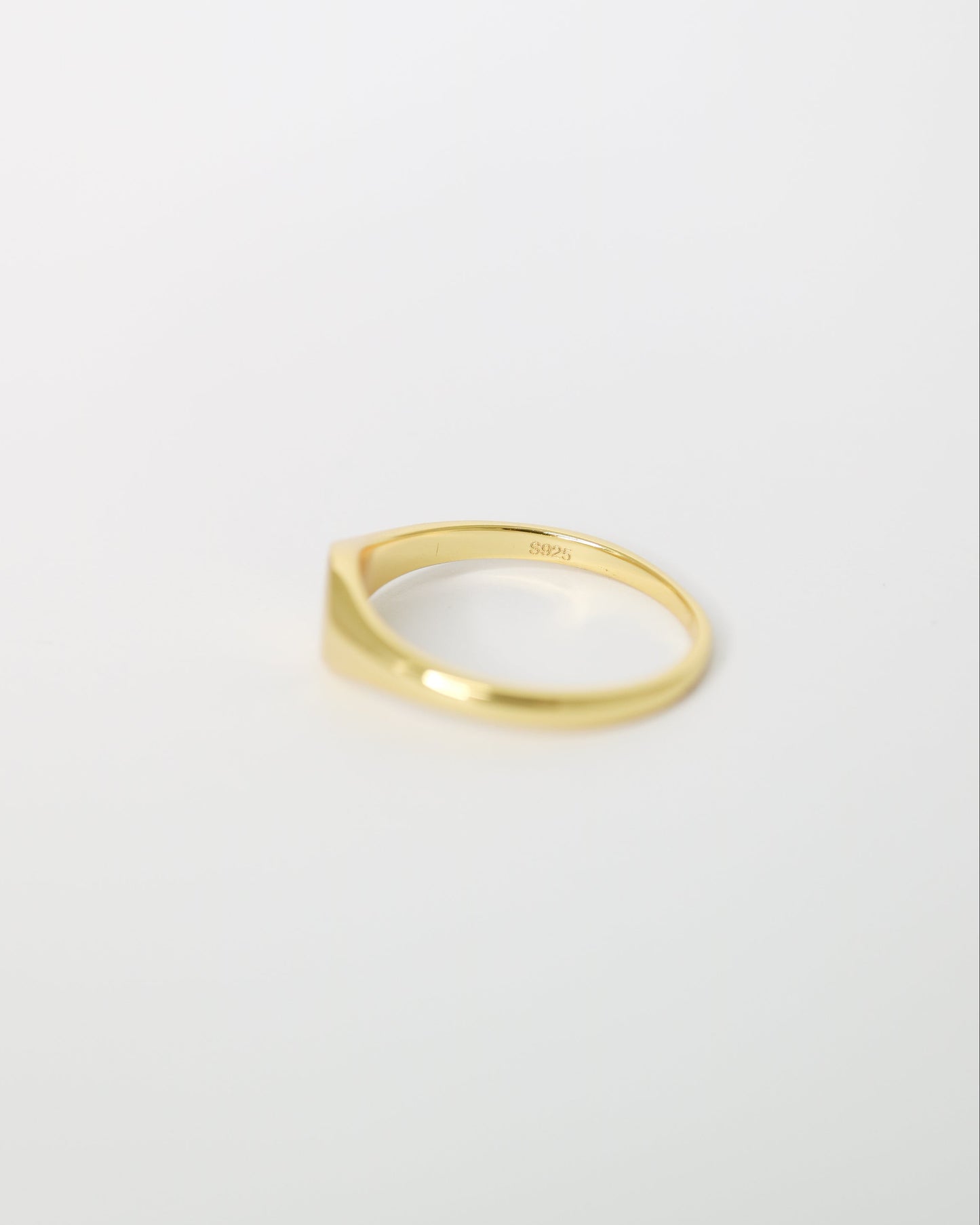 Gold ring on a light gray background