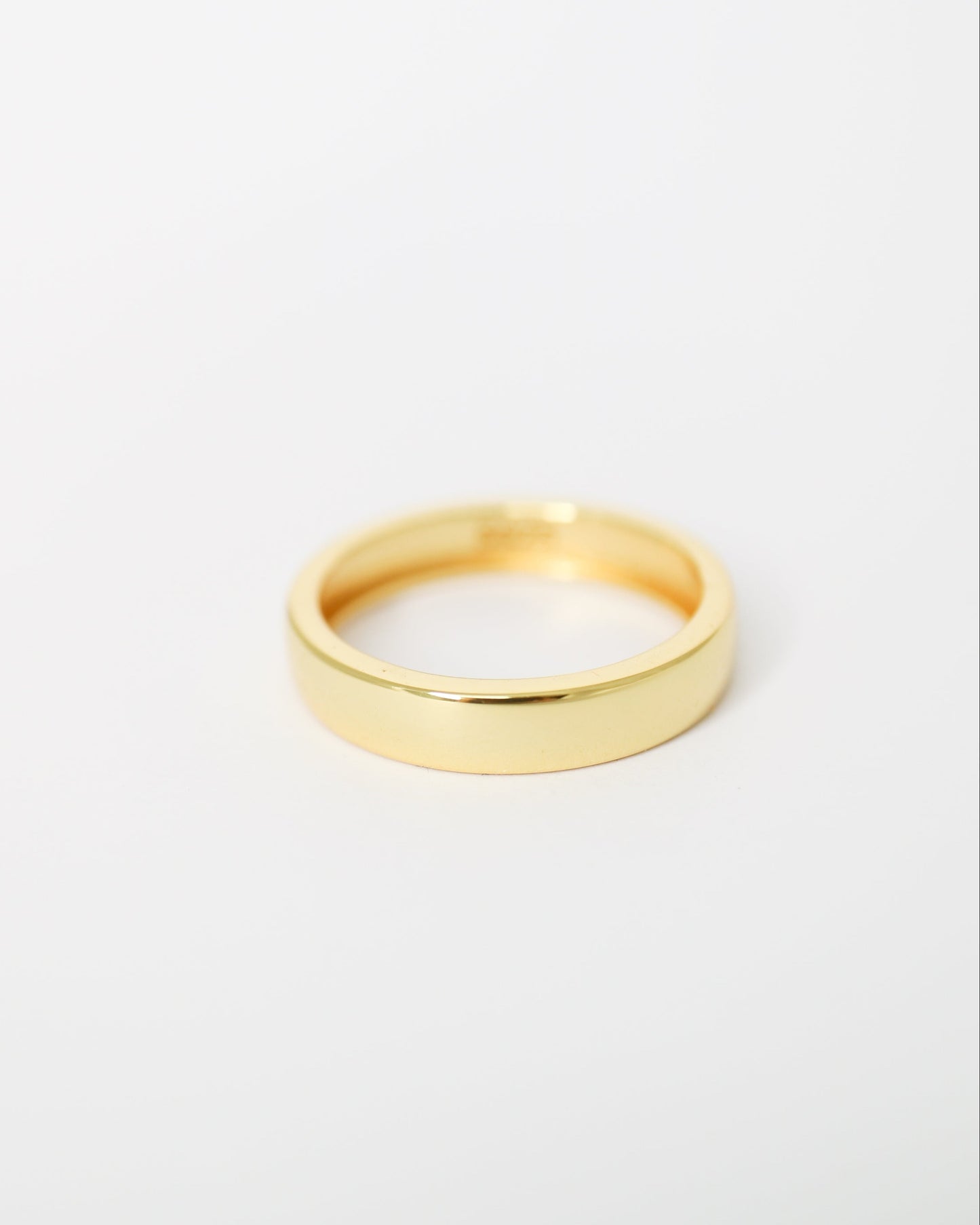 Gold ring on a light gray background