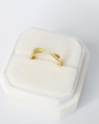 Gold ring on a white cushion with a white background