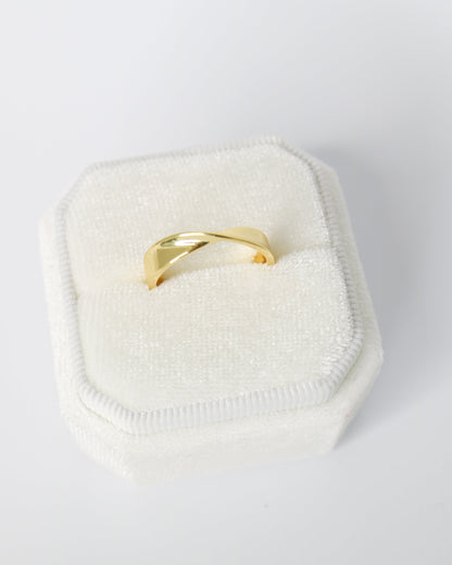 Gold ring on a white cushion with a white background