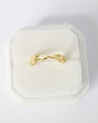 Gold ring on a white cushion with a white background