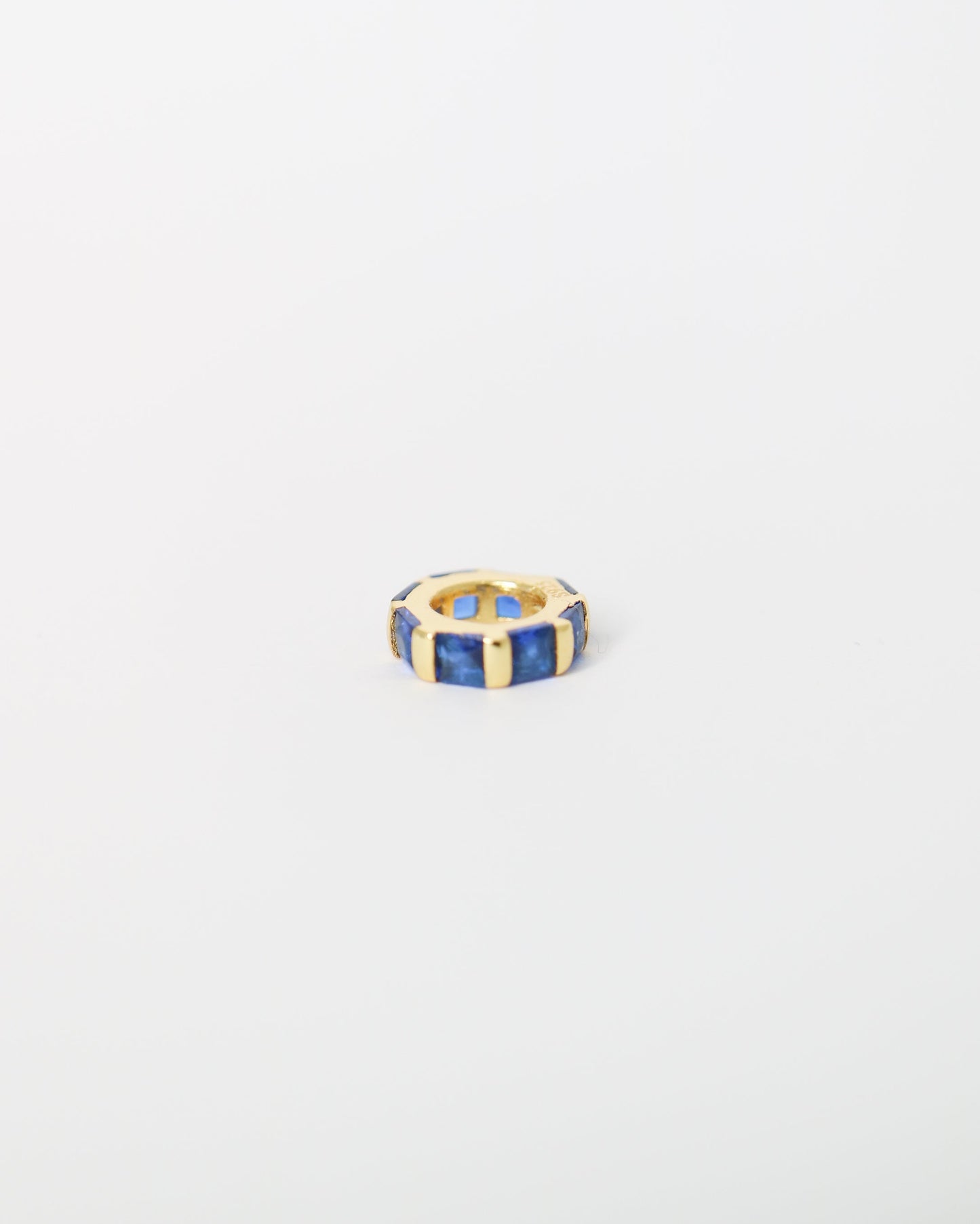 Hexagonal ring with blue and gold accents on a light gray background