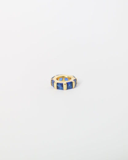 Hexagonal ring with blue and gold accents on a light gray background