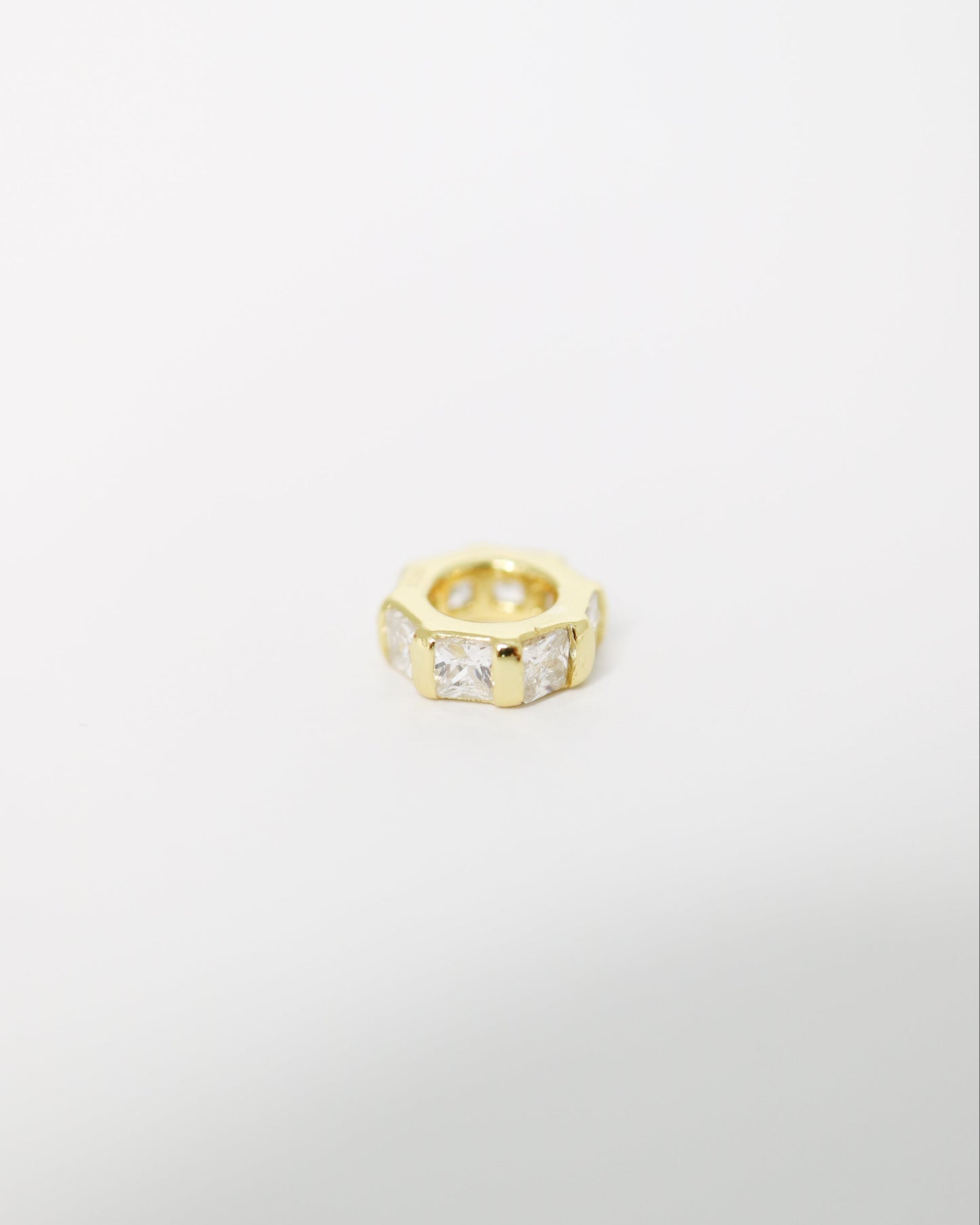 Gold ring with embedded stones on a light gray background