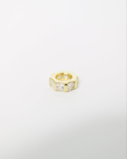 Gold ring with embedded stones on a light gray background