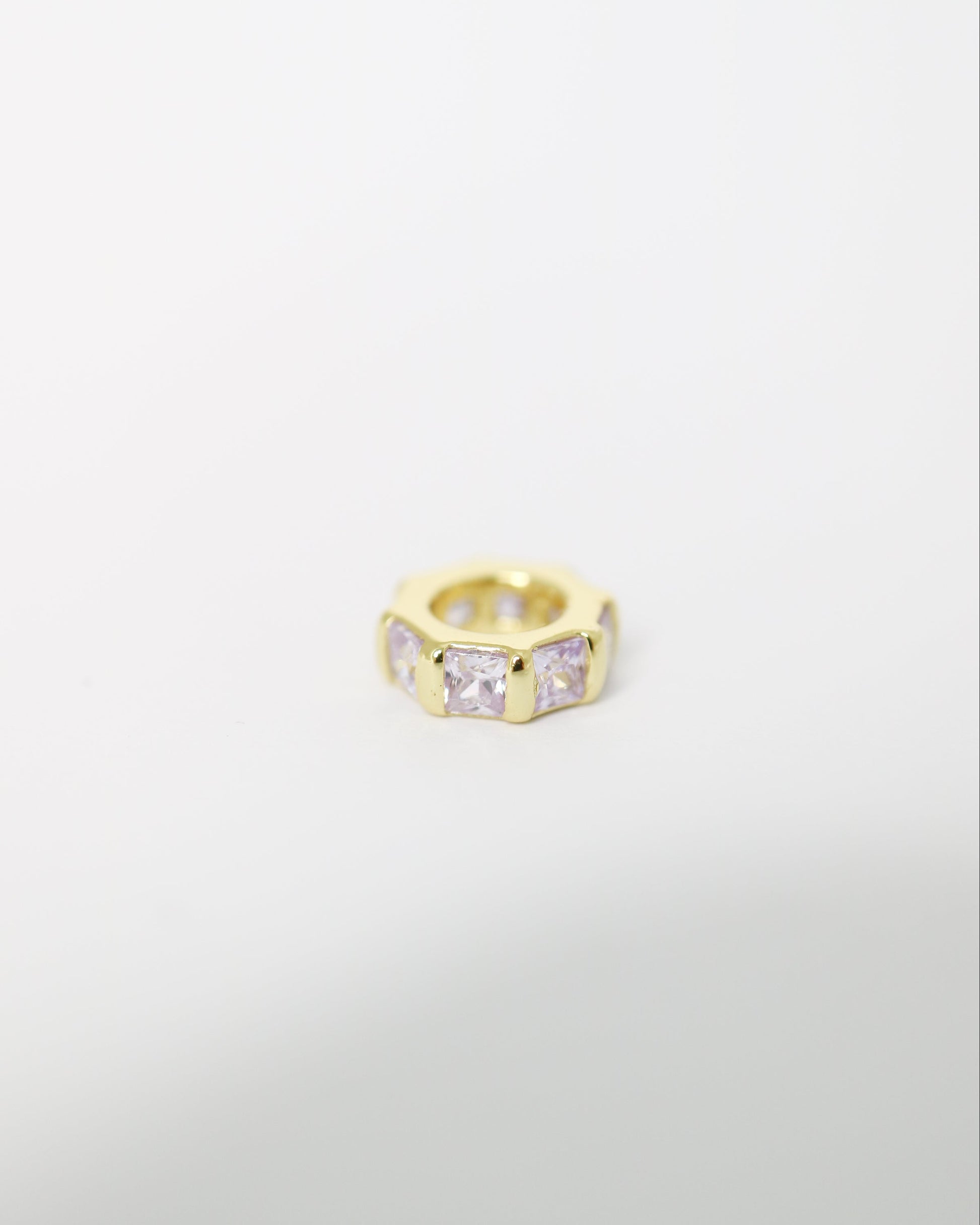 Gold ring with embedded stones on a light gray background