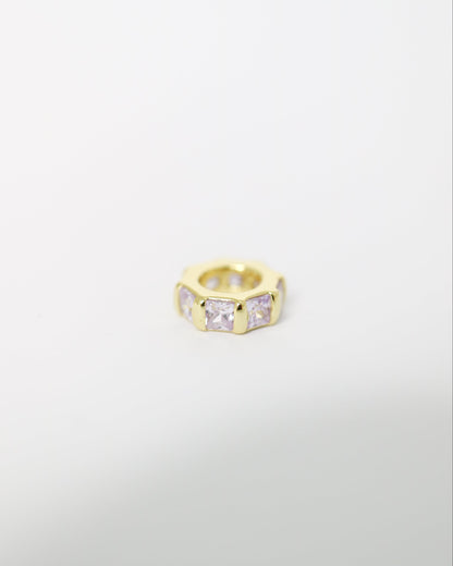 Gold ring with embedded stones on a light gray background