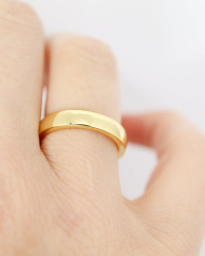 Gold ring on a finger against a white background