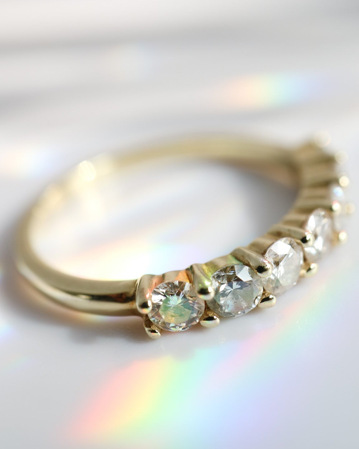 Gold ring with gemstones on a reflective surface