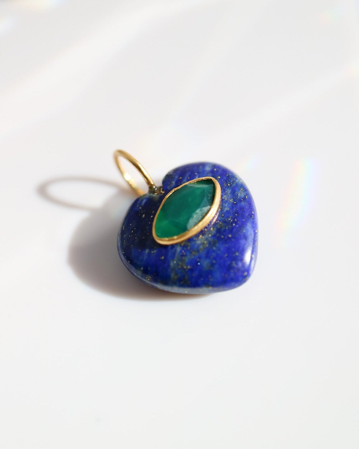 Heart-shaped pendant with green stone and gold accents on a white background