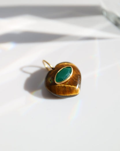 Gold pendant with a green stone on a white background