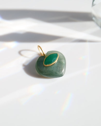 Heart-shaped green pendant with gold frame on a white background
