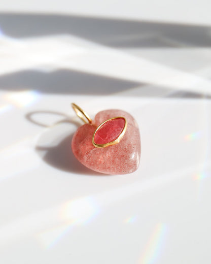 Heart-shaped pink pendant with gold accent on a white background