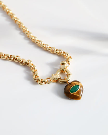 Gold necklace with a heart-shaped pendant on a white background