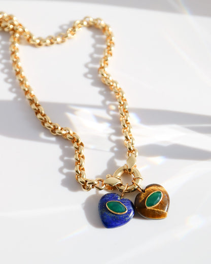 Gold necklace with heart-shaped blue and green charms on a white background