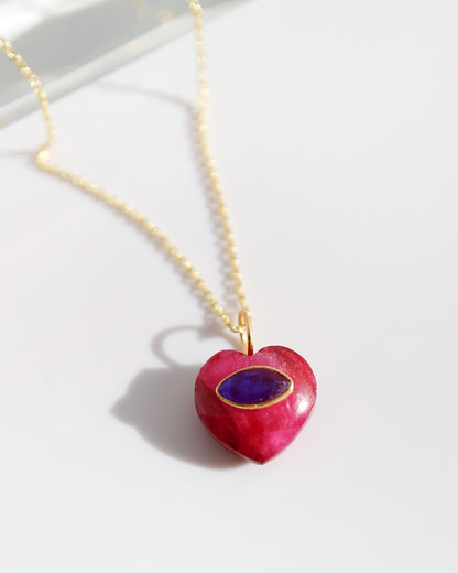 Heart-shaped pendant necklace with a red heart and purple stone on a white background