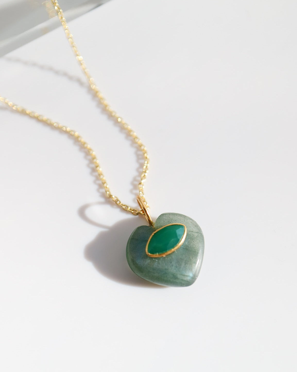 Necklace with a heart-shaped green pendant on a white background
