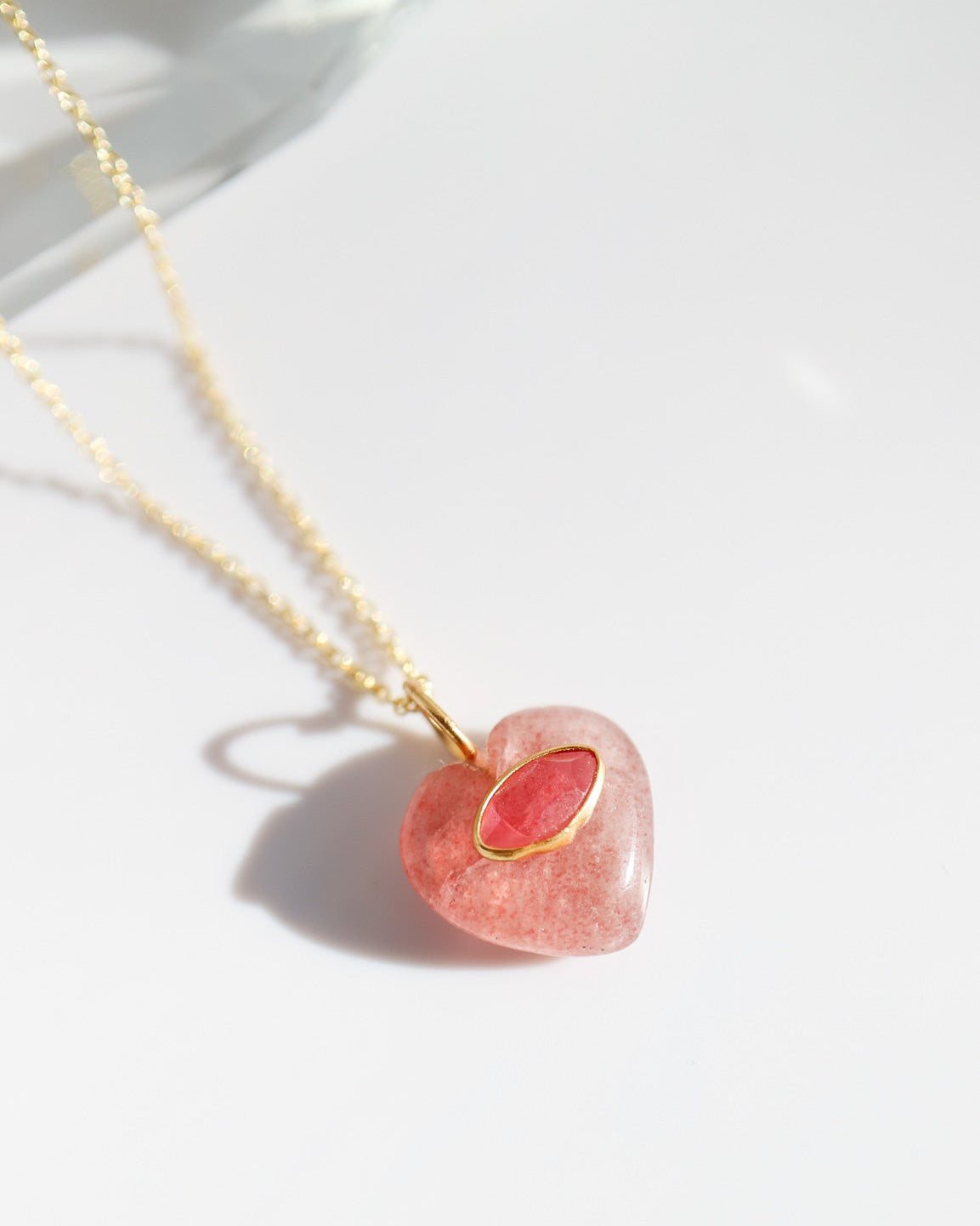 Necklace with a pink heart-shaped pendant on a white background