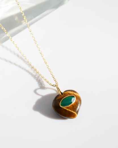 Necklace with a heart-shaped pendant featuring a green stone on a white background