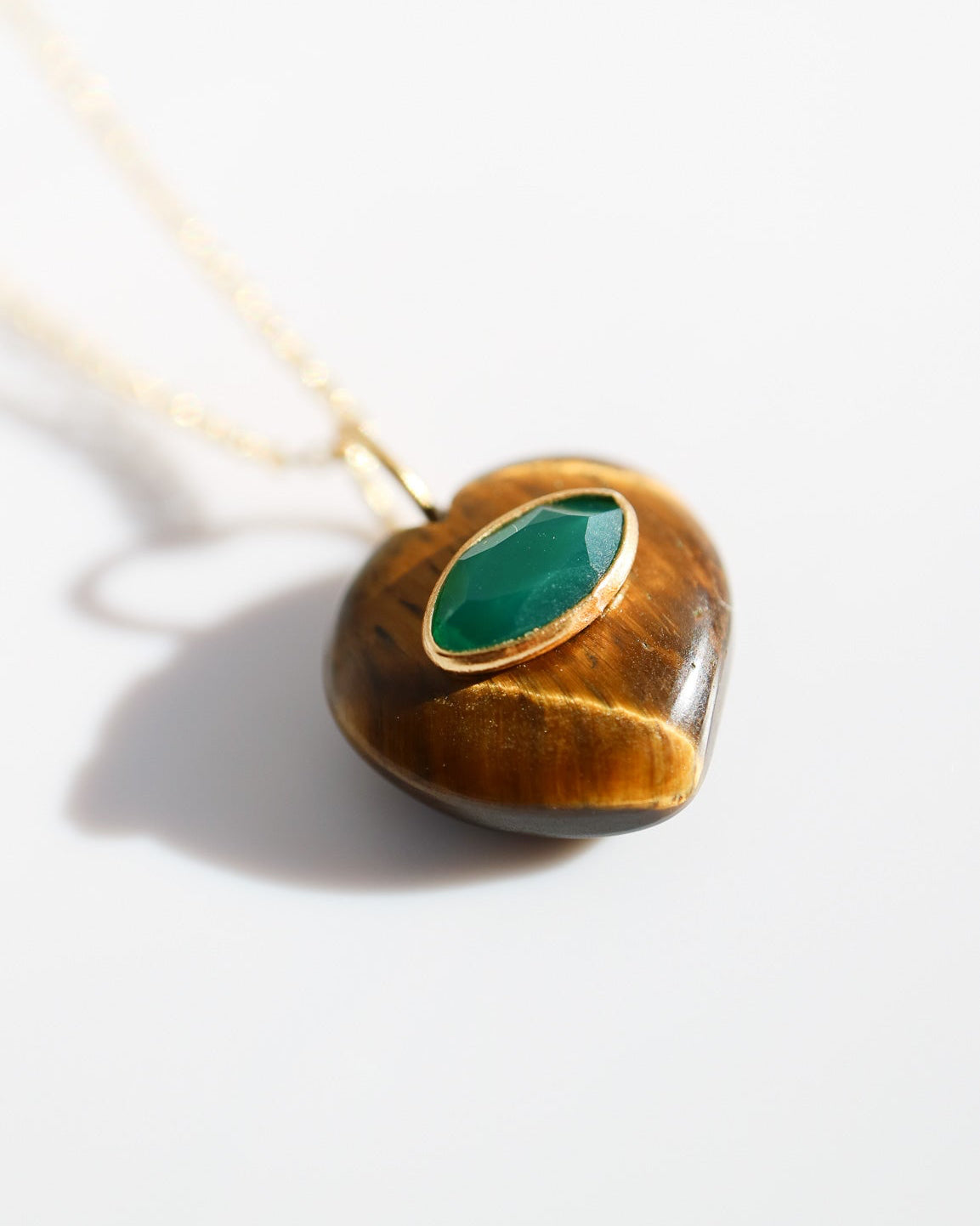 Necklace with a pendant featuring a green stone on a white background