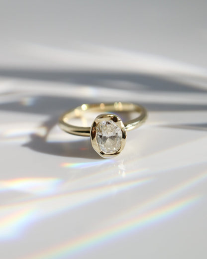 Gold ring with a diamond on a reflective surface