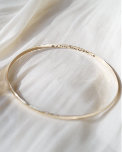 Gold bracelet on a white fabric background