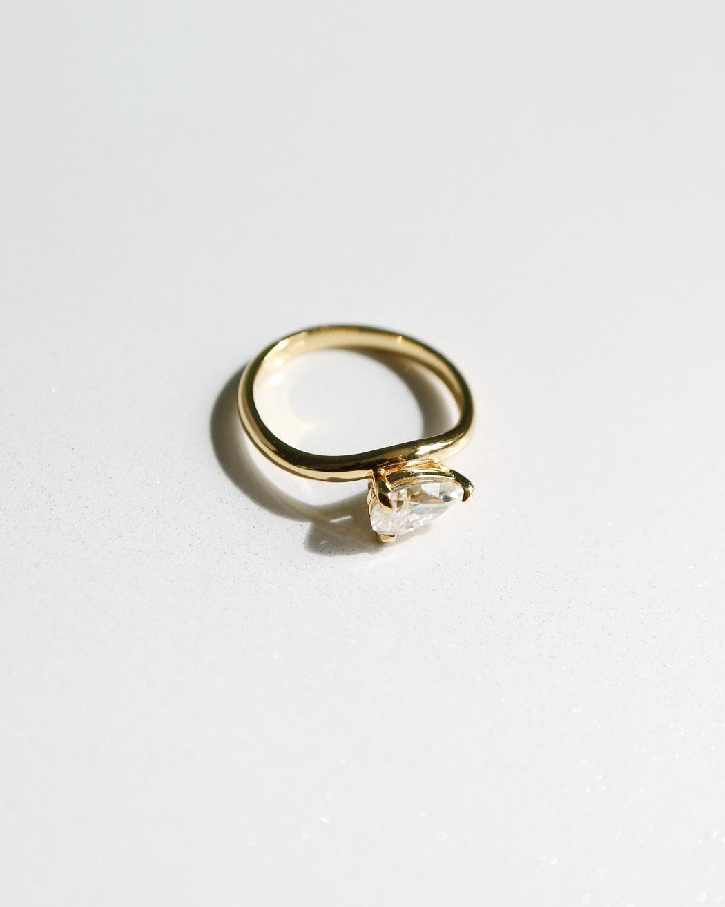 Gold ring with a diamond on a white background