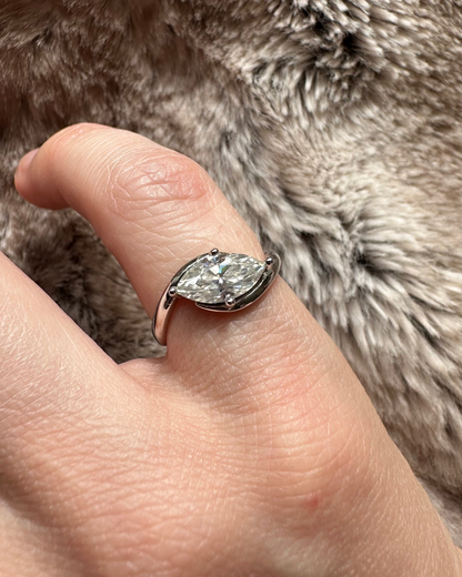 Hand wearing a diamond ring on a fur background