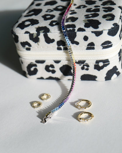 Leopard print jewelry box with a bracelet and rings on a light gray background
