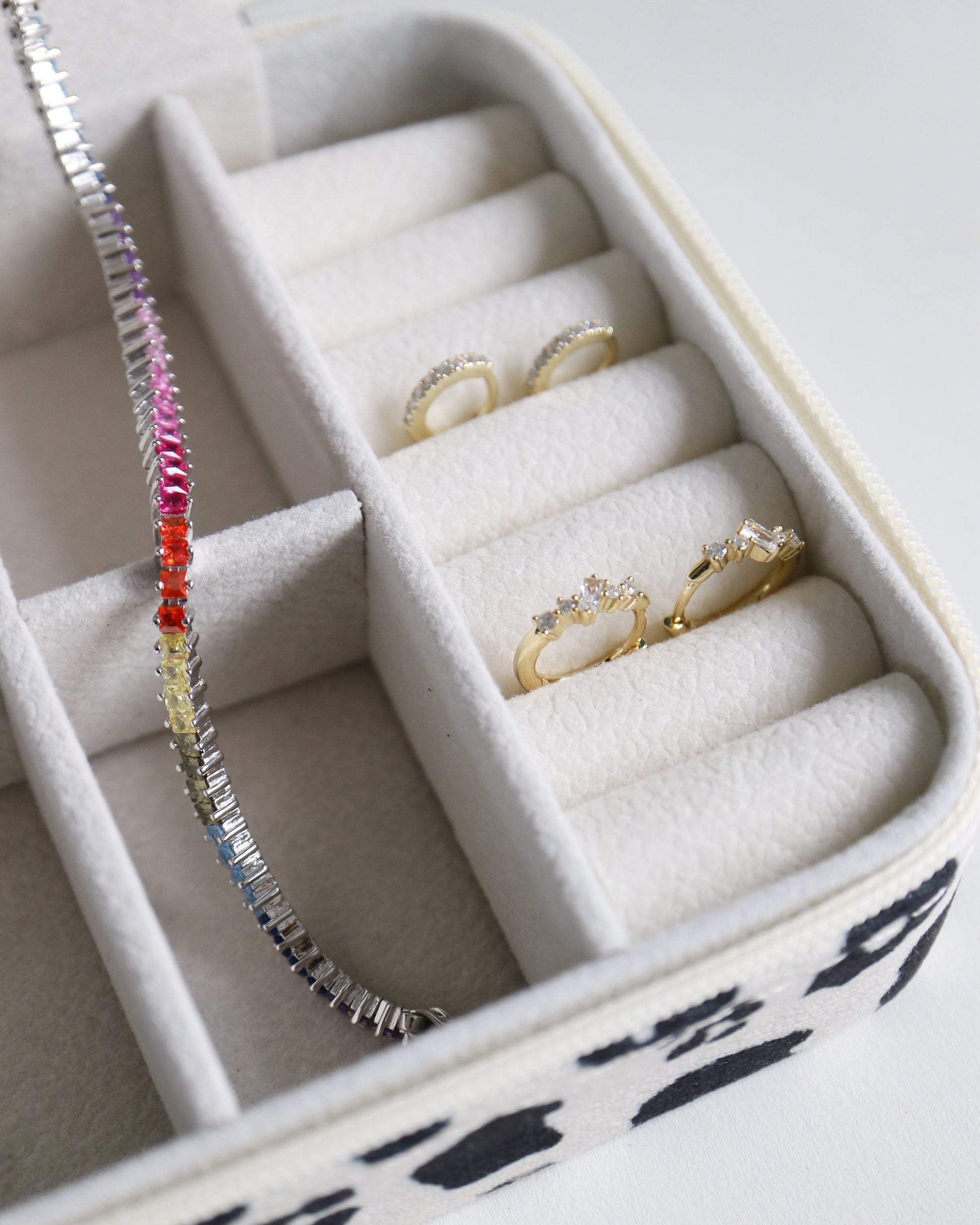 Jewelry box with rings and a bracelet on a white background