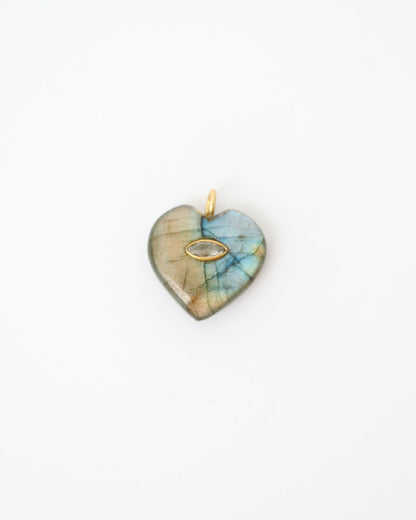 Heart-shaped pendant with a multicolored stone on a white background