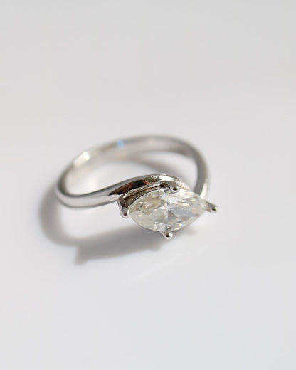 Silver ring with a marquise shaped diamond on a light gray background