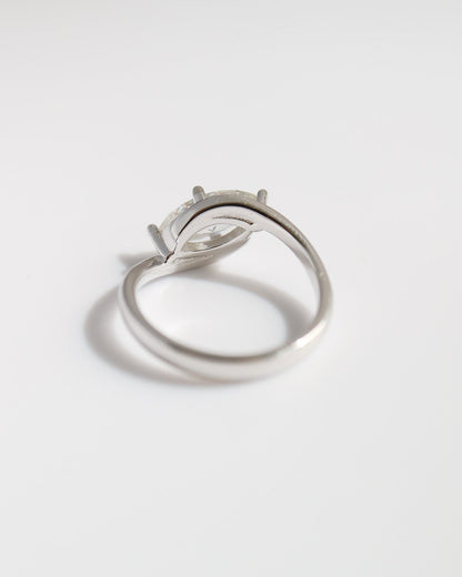 Silver ring with a diamond on a light gray background