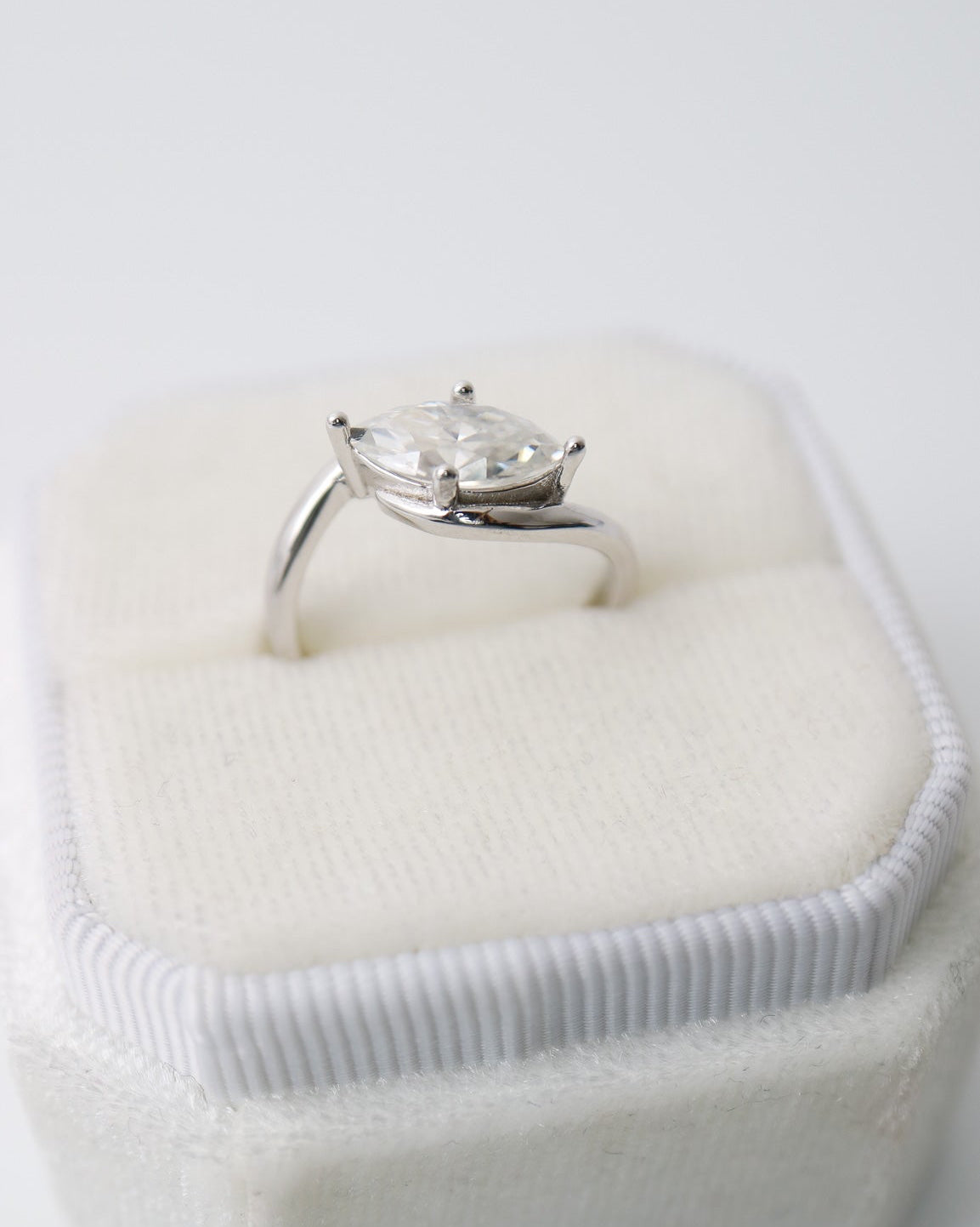 Diamond ring in a heart-shaped box on a white background