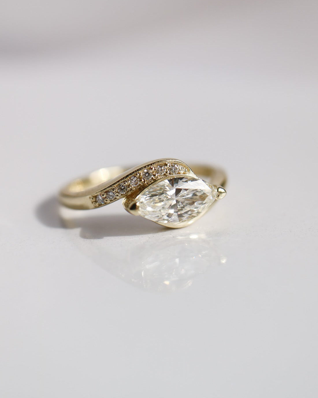 Gold ring with a large diamond on a light gray background