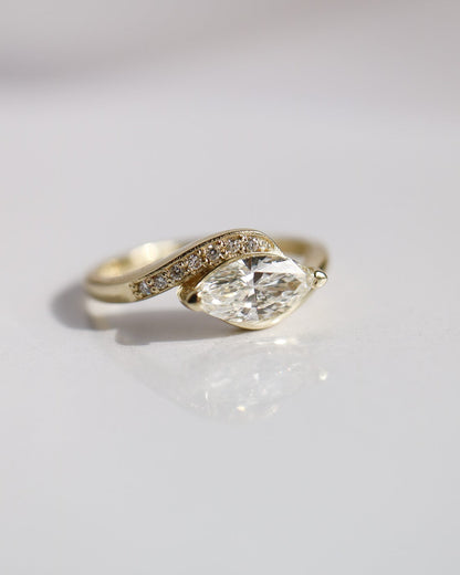 Gold ring with a large diamond on a light gray background