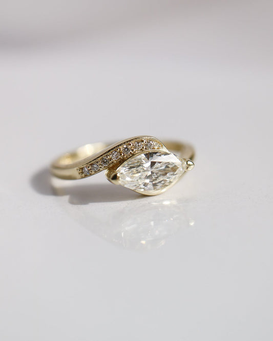 Gold ring with a large diamond on a light gray background