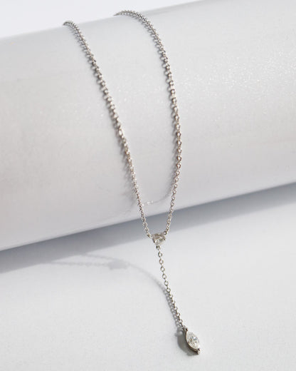 Silver necklace with a small pendant on a white surface