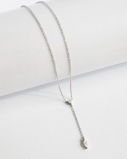 Silver necklace with a small pendant on a white surface