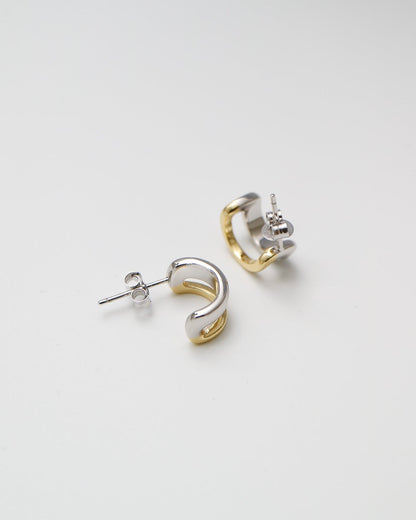 Pair of gold and silver hoop earrings on a white background