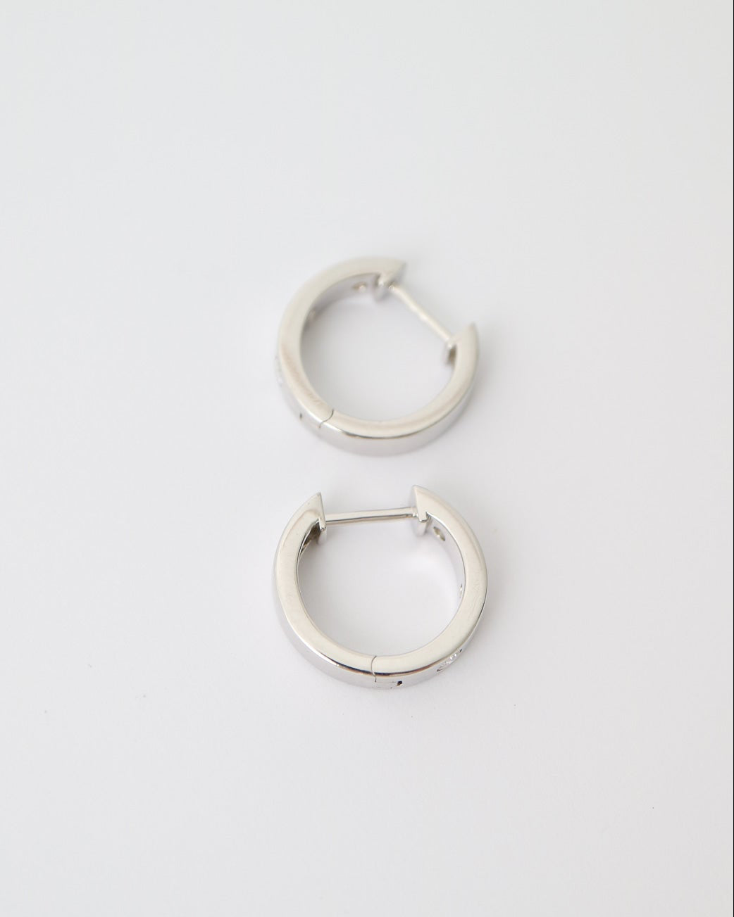 Pair of silver hoop earrings on a light gray background