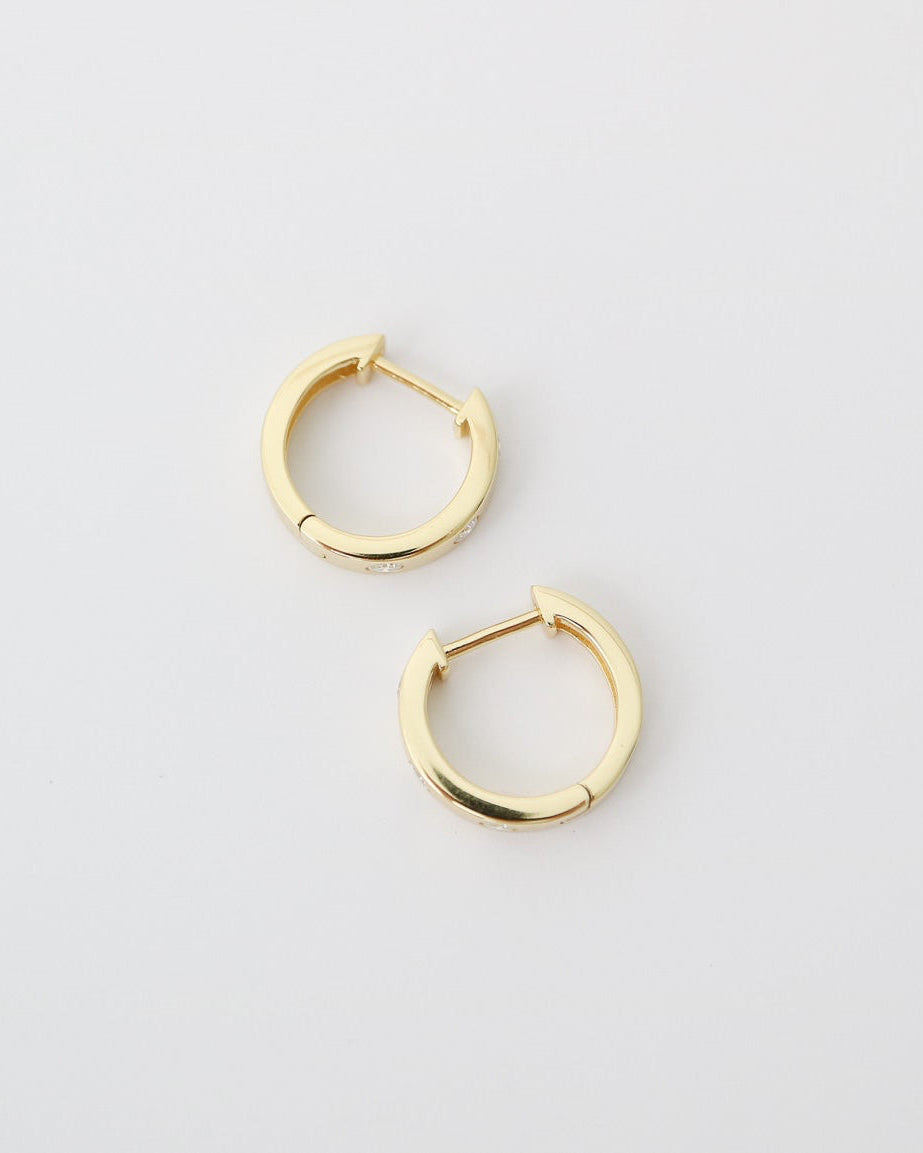 Pair of gold hoop earrings on a light gray background