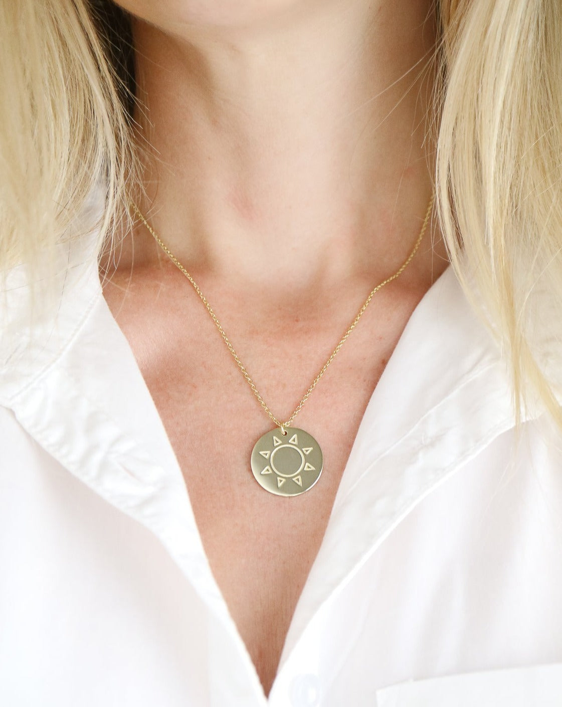 Gold disc necklace on female neck