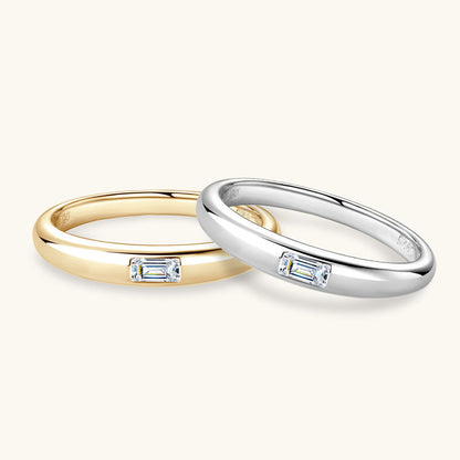 Two rings, one gold and one silver, with embedded diamonds on a white background