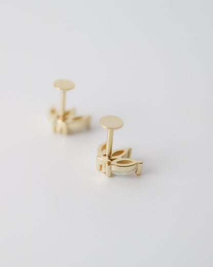 A pair of gold cufflinks with a minimalist geometric design, shown from a side angle on a clean, light gray background.