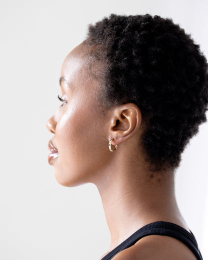 Gold hoop earrings on brown skinned model