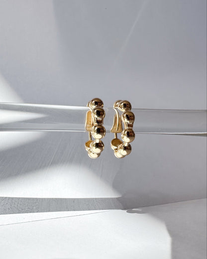 Gold hoop earrings on a light gray background