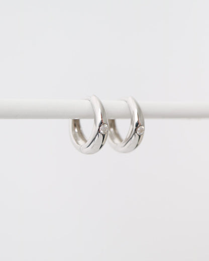 Pair of silver hoop earrings on a white background